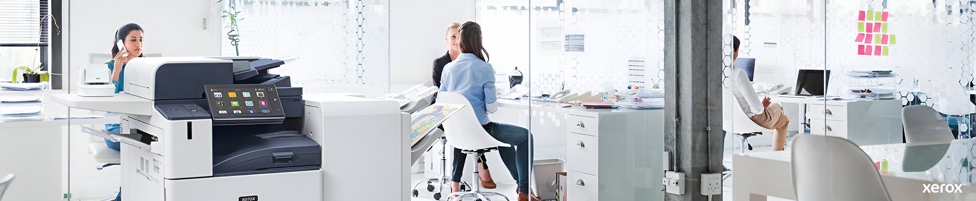 A spacious office featuring a Xerox® printer and a computer on a desk, showcasing a professional work environment.