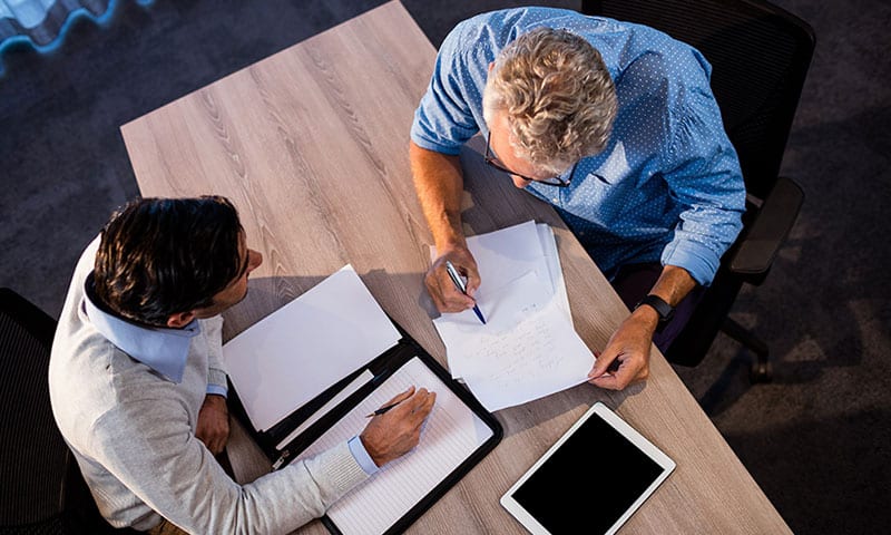 Men reviewing paperwork Men reviewing paperwork