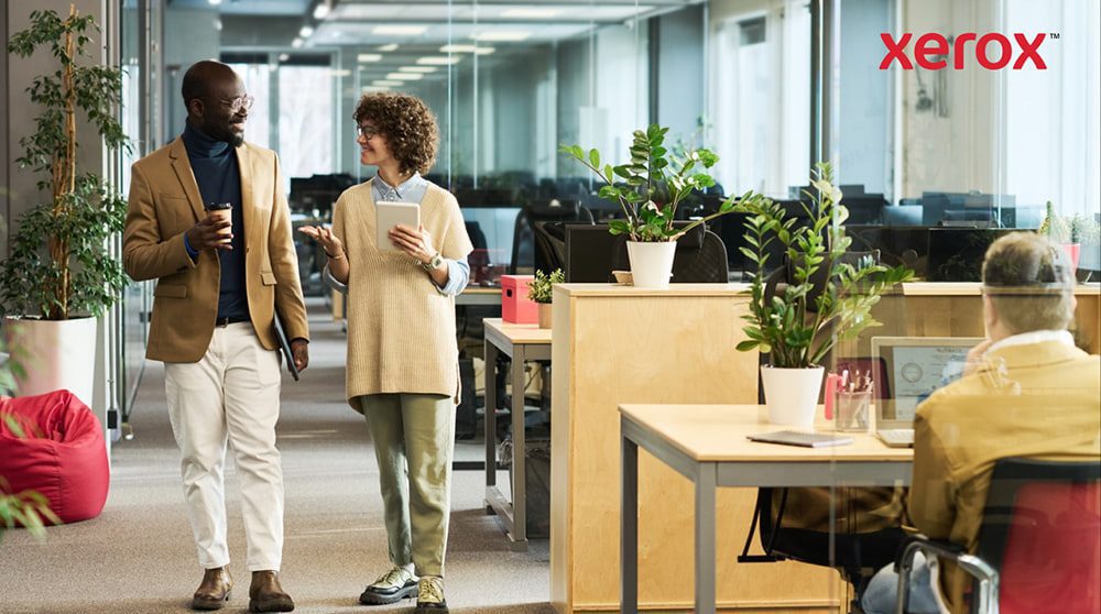 Two professionals walking and talking in a modern office