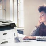 Xerox® B315 Multifunction Printer in work situation Young woman working at her computer next to a Xerox® B315 multifunction printer.