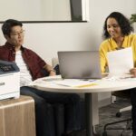 Xerox® C410 Colour Printer in the workplace Two people in the office next to the Xerox® C410 Colour Printer