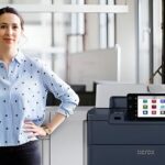 A woman standing beside the Xerox® PrimeLink® C9200 Series Printer in a modern office environment A woman standing beside the Xerox® PrimeLink® C9200 Series Printer in a modern office environment