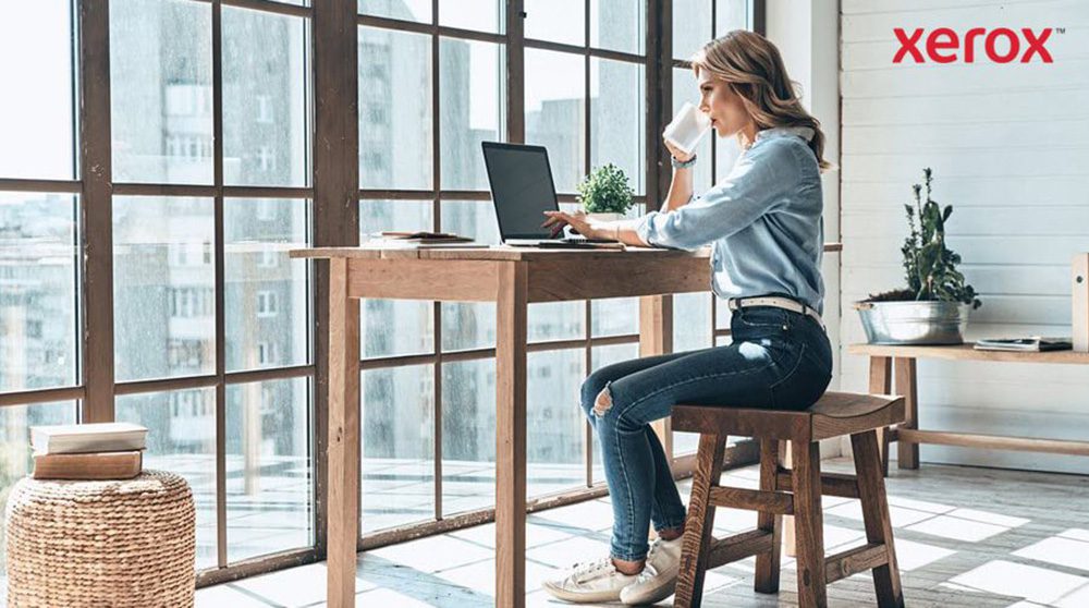 A woman at a desk, utilizing a laptop, demonstrating concentration and productivity.