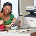 Xerox® VersaLink® B415 Multifunction Printer in the workplace Two women using a tablet in front of a Xerox® VersaLink® B415 Multifunction Printer