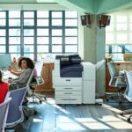 Xerox® VersaLink® B7100 Series, monochrome printer in the workplace Team at work in an open space with the Xerox® VersaLink® B7100 Series monochrome printer